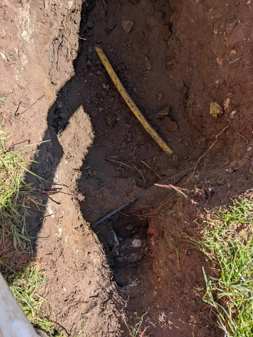 Trial hole exposing a yellow gas pipe